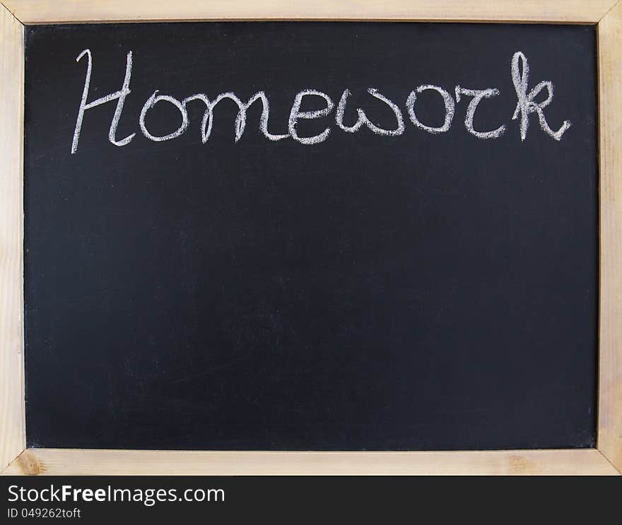 A black school chalkboard with an inscription homework. A black school chalkboard with an inscription homework