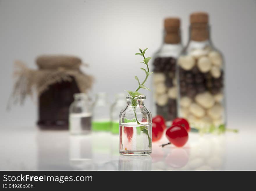 A glass, cherry and yellow flowers on a white background. Flowers in the water.