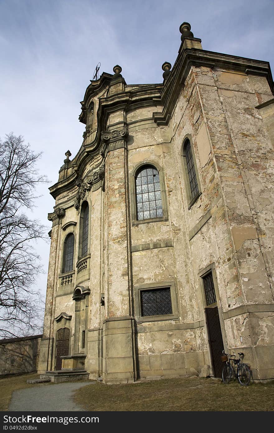 Look at the baroque church ceiling, view of the church by, church on a sunny autumn day, bicycle leaning against a wall round the church. Look at the baroque church ceiling, view of the church by, church on a sunny autumn day, bicycle leaning against a wall round the church