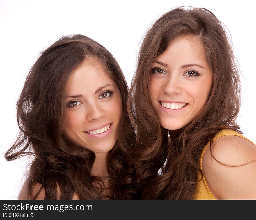 Two girls sisters - GEMINI on a white background. They are smiling.