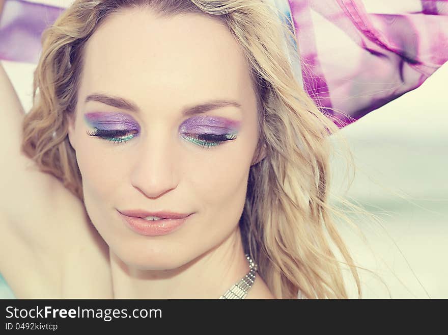 A beautiful young woman with flowing colorful fabric behind her. A beautiful young woman with flowing colorful fabric behind her.