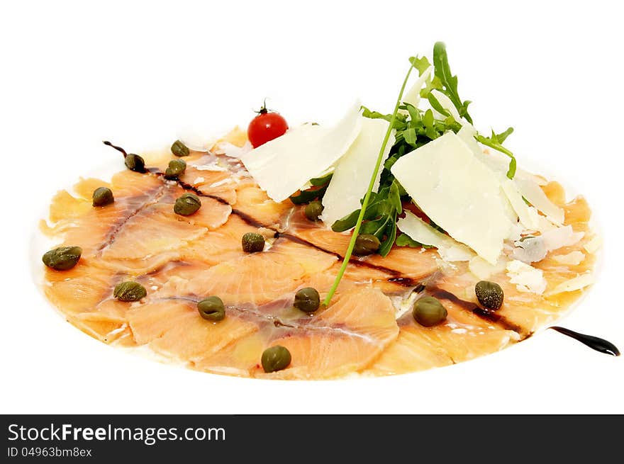 Fish carpaccio with green on a white plate