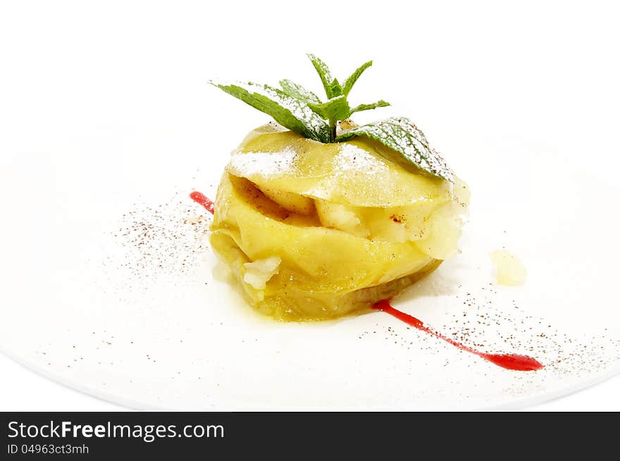 Baked apple with cinnamon sauce on a white background