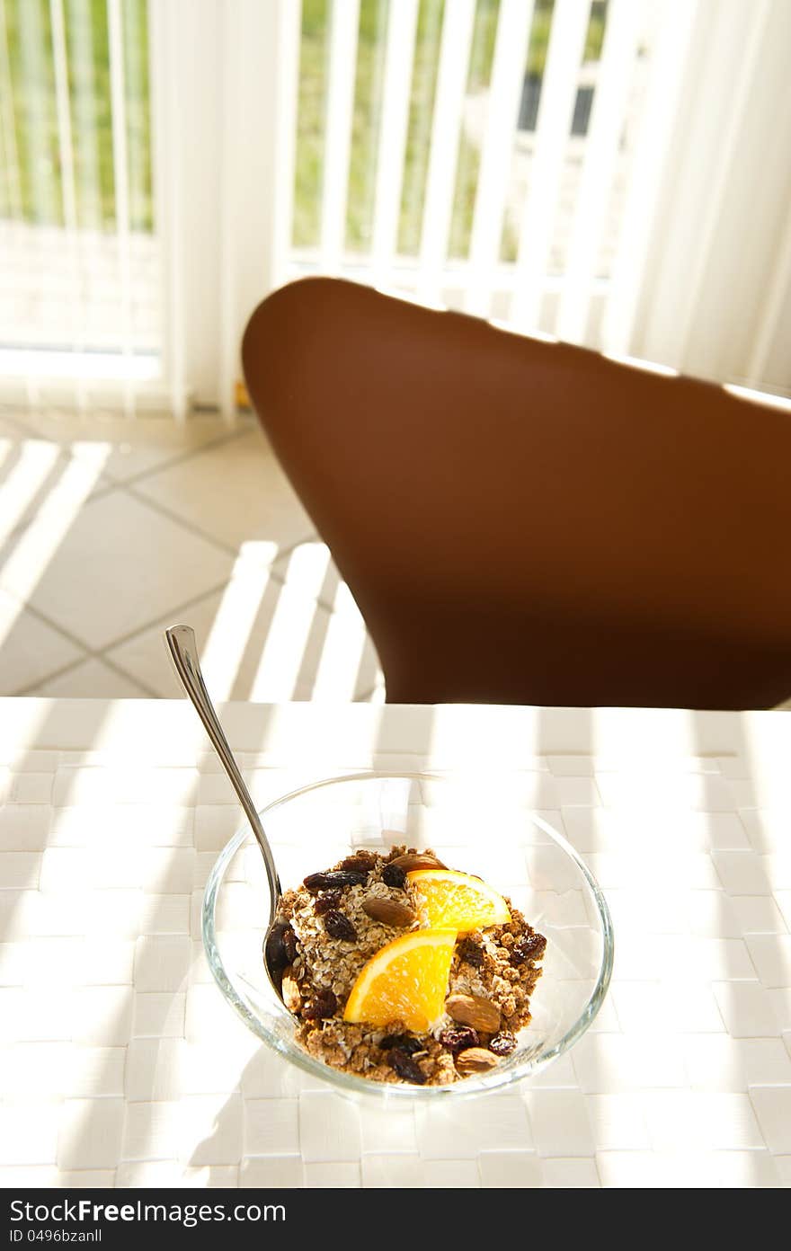 Healthy muesli with orange in the morning sun