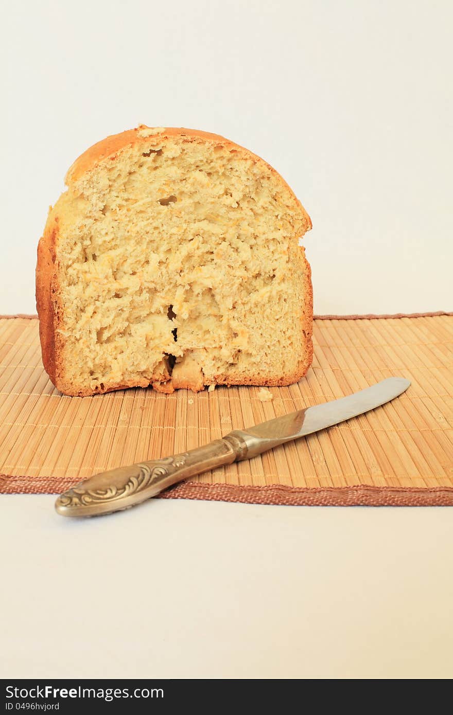 Half a loaf of bread shown in close-up on the tablecloth, prepared with the addition of tykvy.Ryadom knife is made ​​of white steel. Half a loaf of bread shown in close-up on the tablecloth, prepared with the addition of tykvy.Ryadom knife is made ​​of white steel.