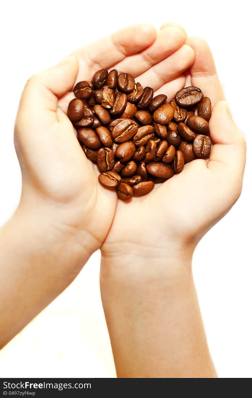 If you look closely at this picture shows two hearts. one heart out of the hands, the second of coffee beans. Children&#x27;s hands holding coffee. If you look closely at this picture shows two hearts. one heart out of the hands, the second of coffee beans. Children&#x27;s hands holding coffee
