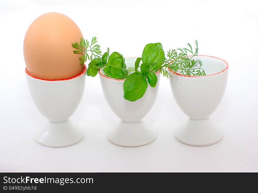 Egg and three eggcups , decorated with greenery. Egg and three eggcups , decorated with greenery