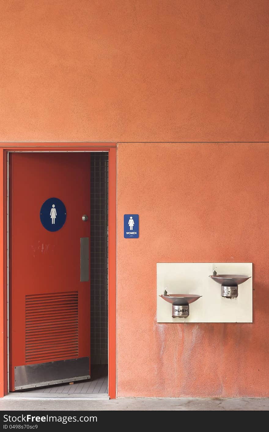 Orange wall women toilet with front sink