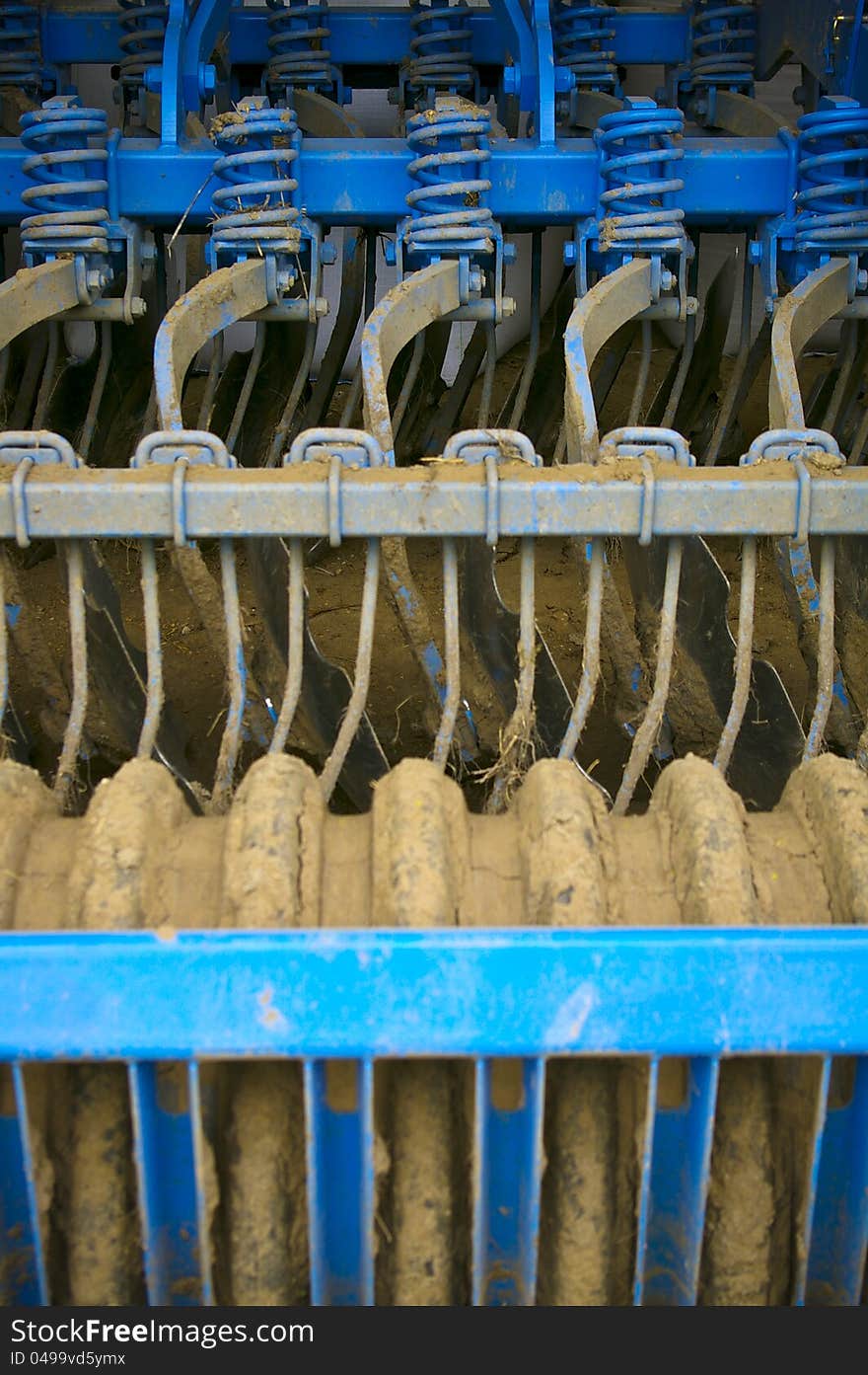 Blue farm machinery covered with dirt. Blue farm machinery covered with dirt