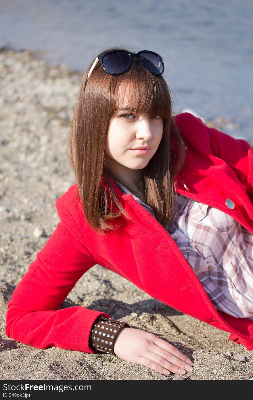 A girl in a bright red coat and sunglasses. A girl in a bright red coat and sunglasses