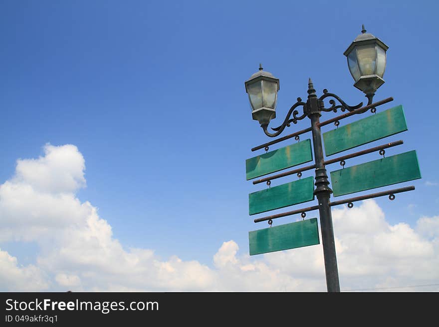 Antique lamp with traffic wood signboard on sky