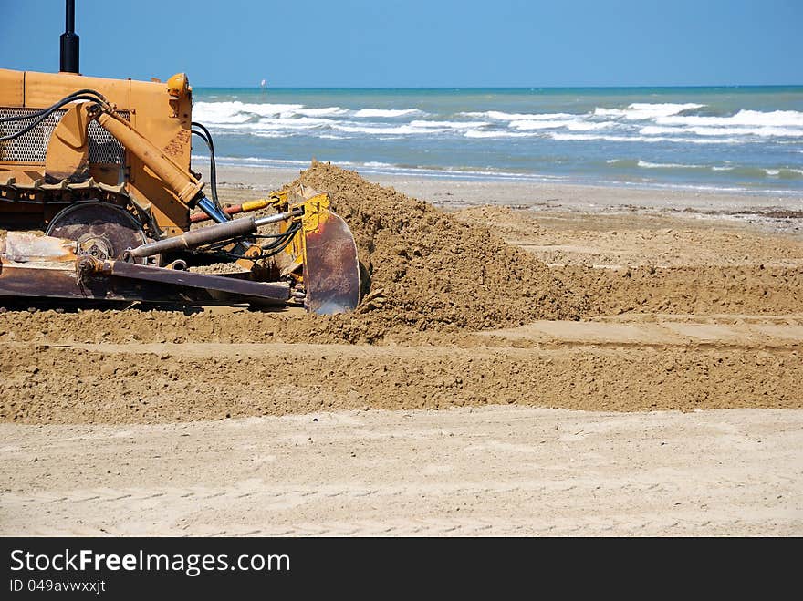 Bulldozer in the sand near the sea