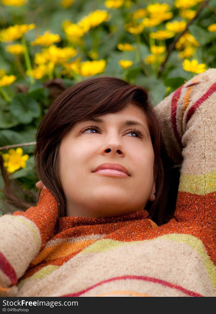 A portrait of a gorgeous young woman, reclining amid a field of bright yellow flowers, looking peaceful and content. A portrait of a gorgeous young woman, reclining amid a field of bright yellow flowers, looking peaceful and content