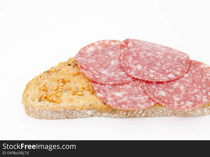 Seed bread with tomato and salami and white background. Seed bread with tomato and salami and white background