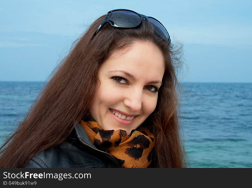 Young woman with sunglasses on the sea coast.