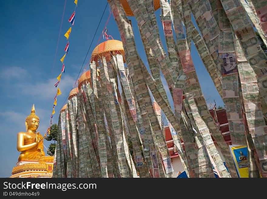 Beautiful exterior decoration in wat thai on holy day with line of flags and money lantern above the floor connecting to the big golden buddha image. Beautiful exterior decoration in wat thai on holy day with line of flags and money lantern above the floor connecting to the big golden buddha image.