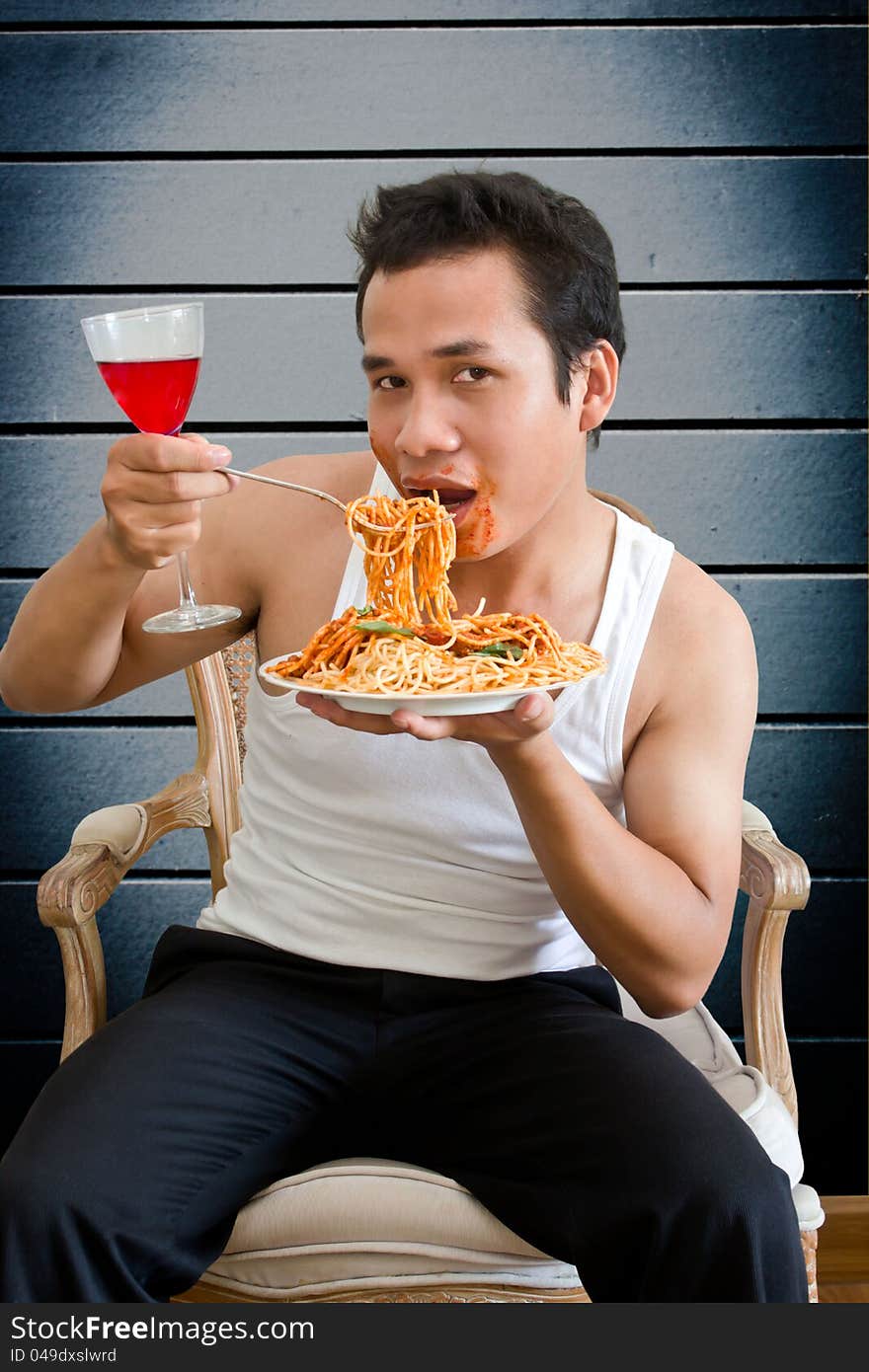Man eating spaghetti with behind old wall