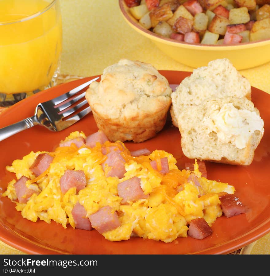 Scrambled eggs with ham, biscuits and orange juice breakfast. Scrambled eggs with ham, biscuits and orange juice breakfast