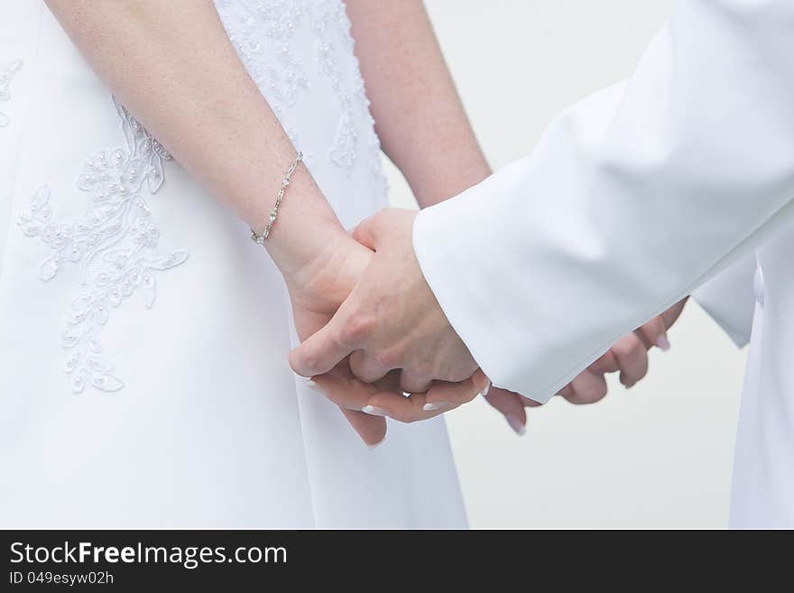 A bride and groom holding hands during the wedding ceremony