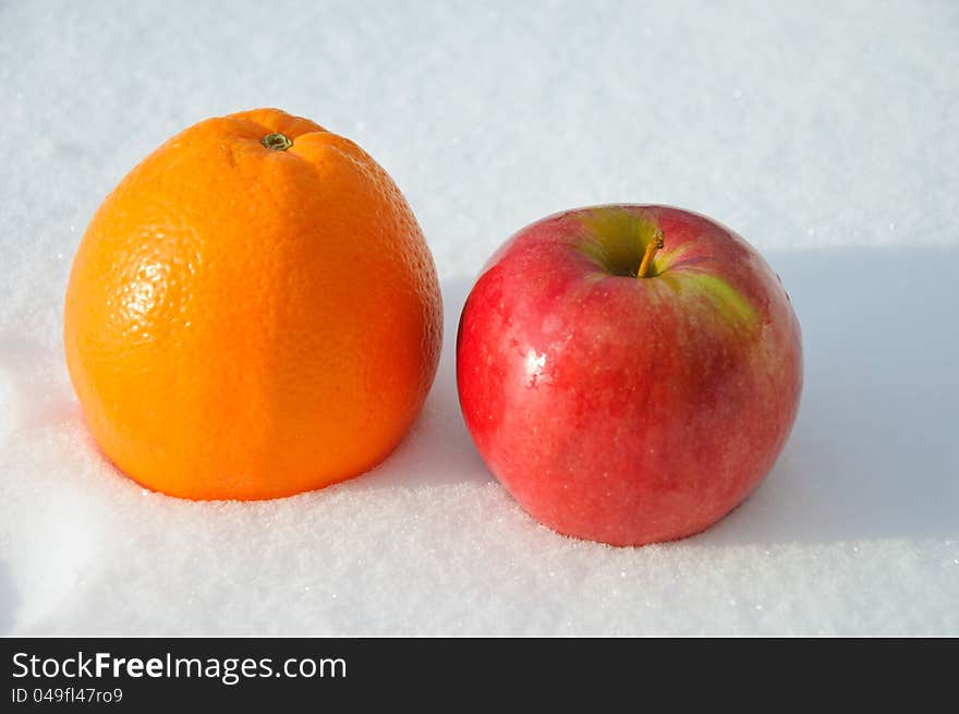 The Image Of Apple And Orange On Snow