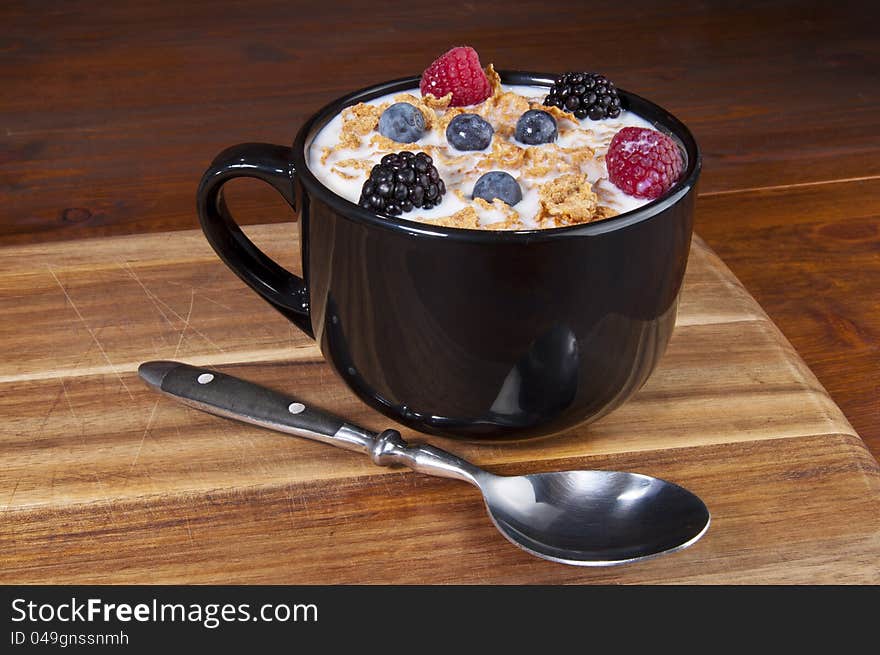 Cornflakes cereal bowl with berries and milk