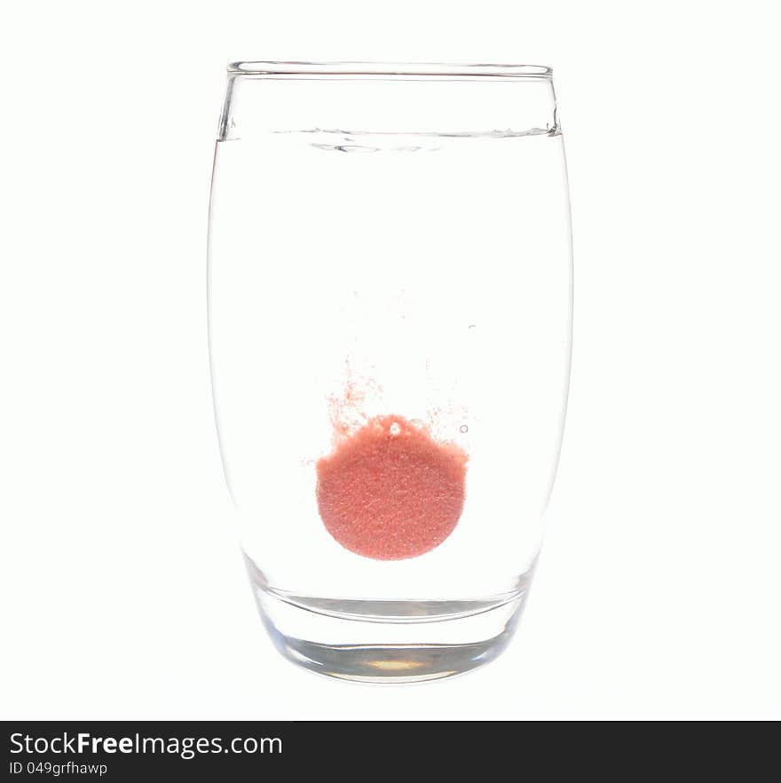 An effervescent tablet dissolving in a glass of water. An effervescent tablet dissolving in a glass of water