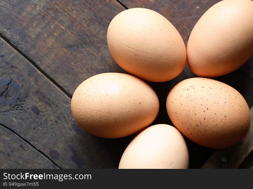 Few chicken eggs on wooden surface with free space for text