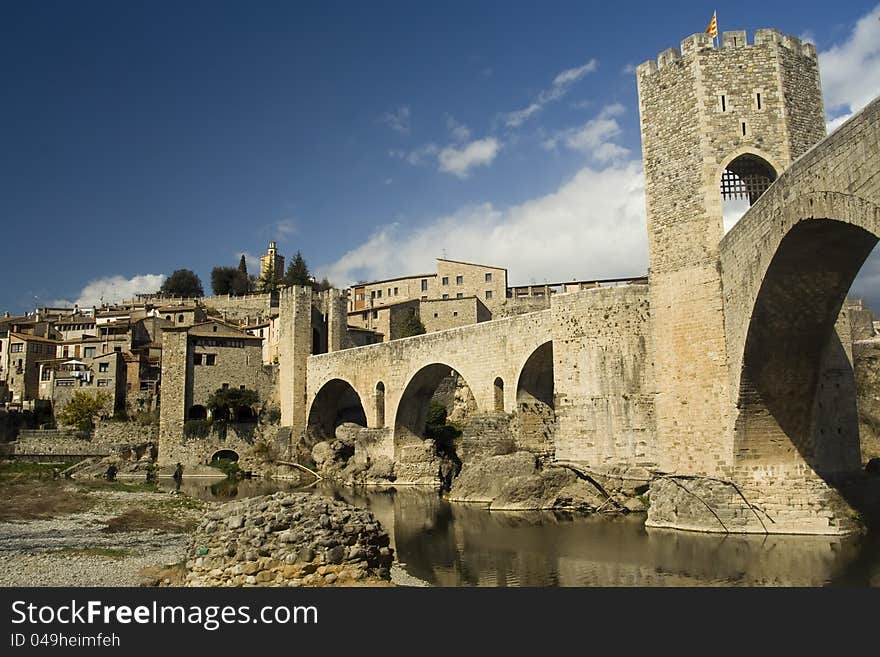 Cityscape of Besalu, Spain, at early spring. Roman bridge, now pedestrian, with Catalonia flag is at the front.