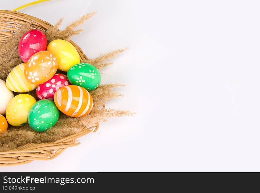 Basket with colorful Easter eggs on a grey background