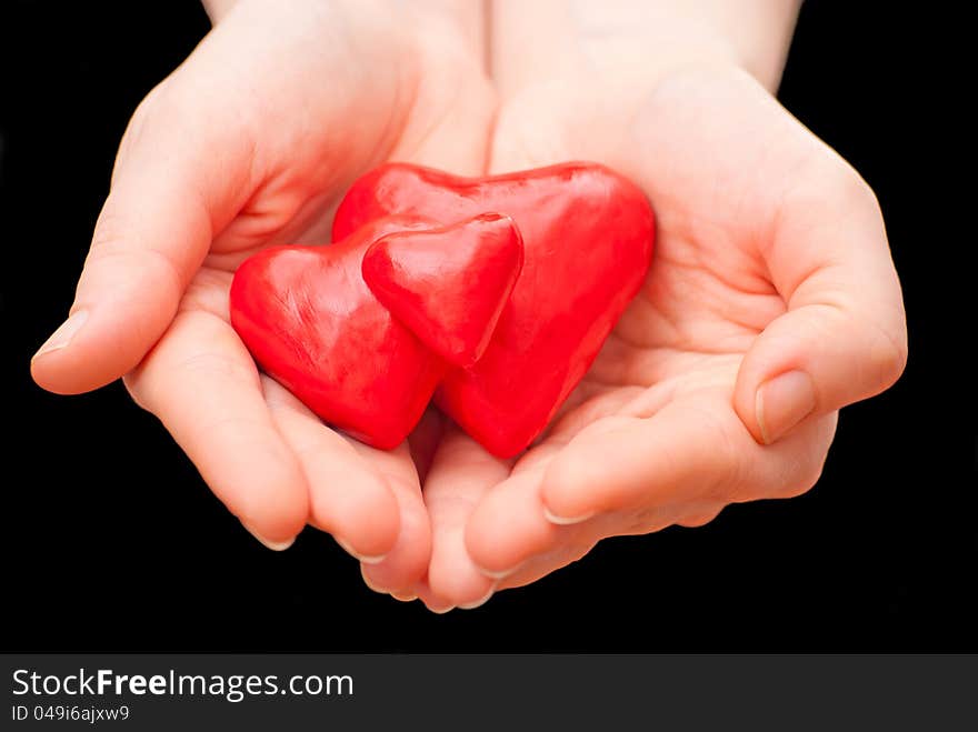 Plasticine heart in hand on a black background