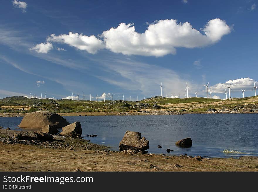 Landscape with lake, clouds and aerogenerators in background