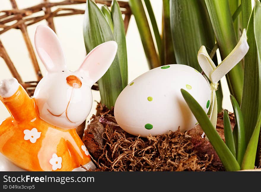 Colorful easter egg on old nest and rabbit decoration