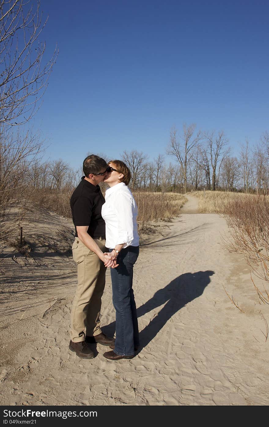 A mature couple in love on the beach during springtime. A mature couple in love on the beach during springtime.