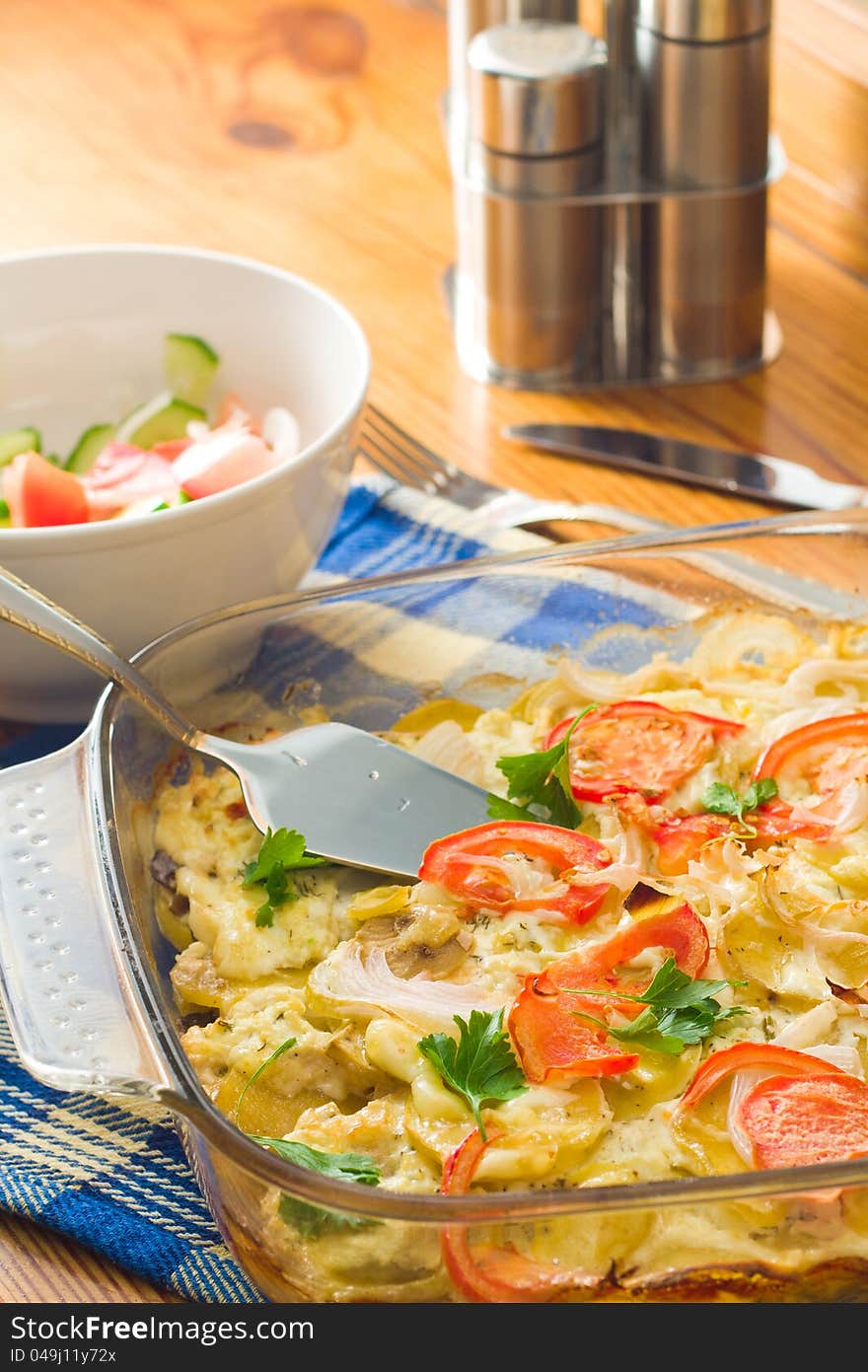 Vegetable Casserole on a wooden table with a napkin and knife and fork near by