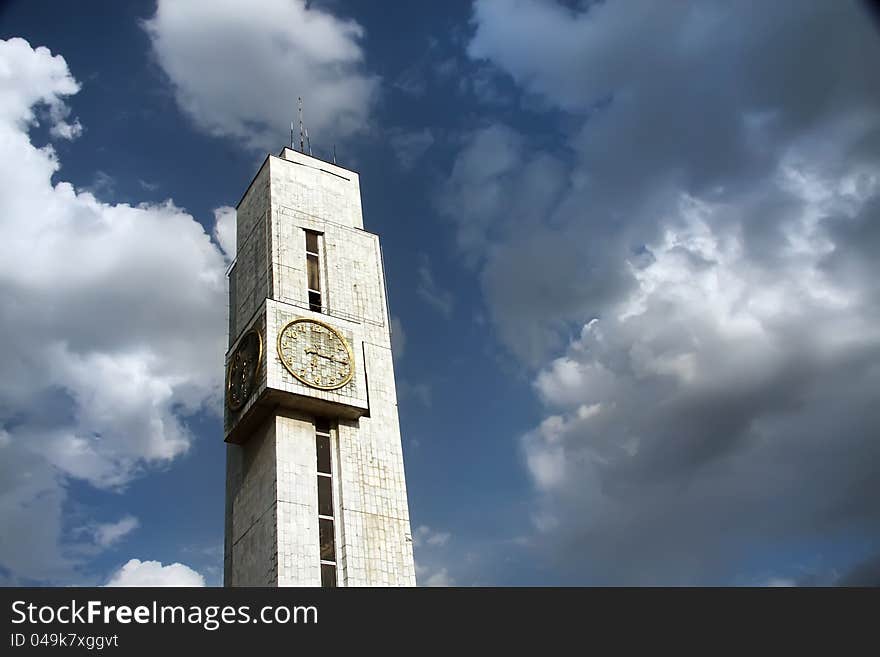 Tower with hours. Against cloudy sky