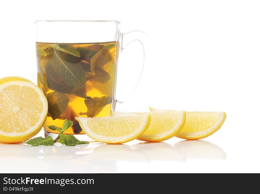 Mint tea and fresh lemons over white background