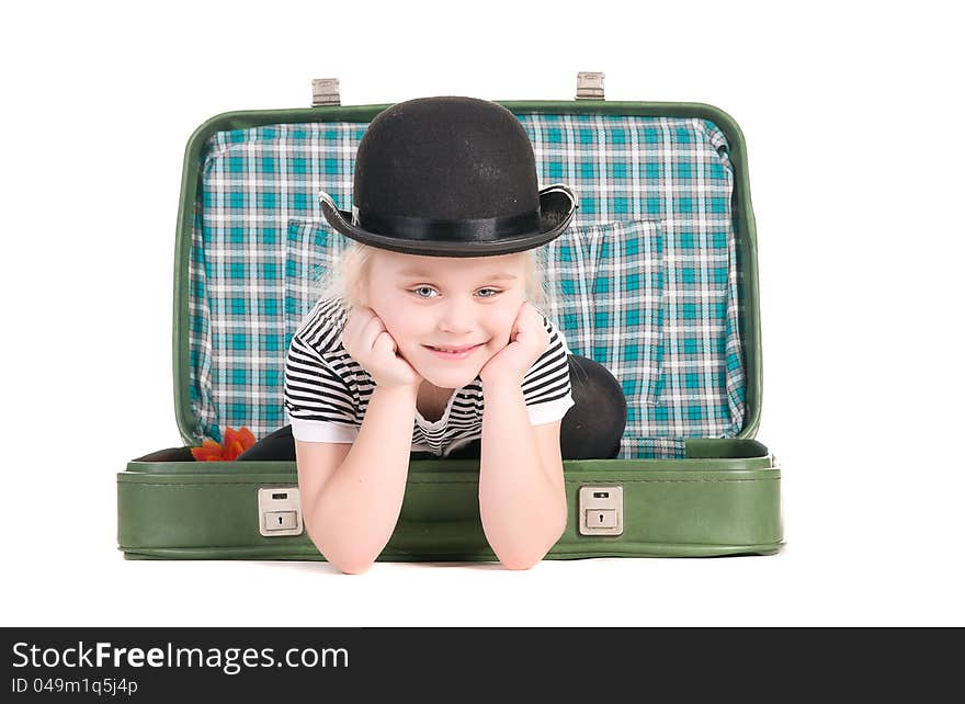 Child sitting in an old green suitcase