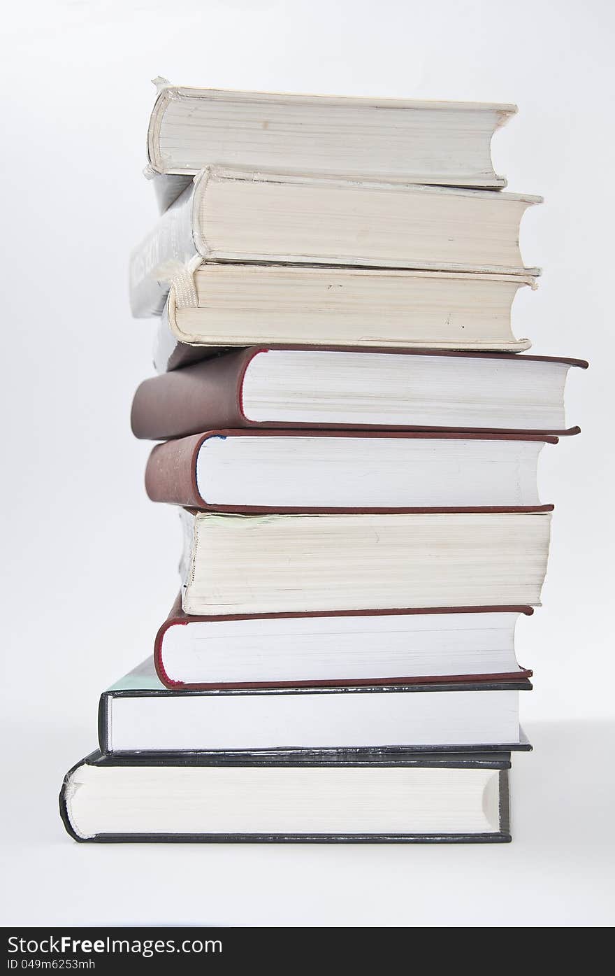 Stack of books with opened notebook on white