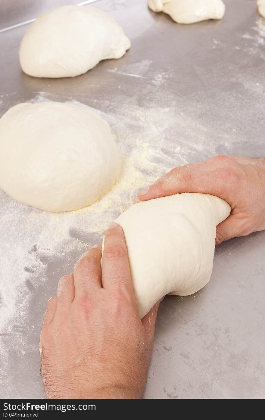 Baker kneads the flour on a shelf, to make bread. Baker kneads the flour on a shelf, to make bread