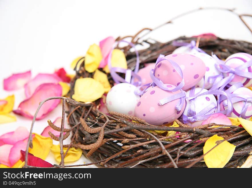 Multicolored Easter eggs in a nest and wicker basket