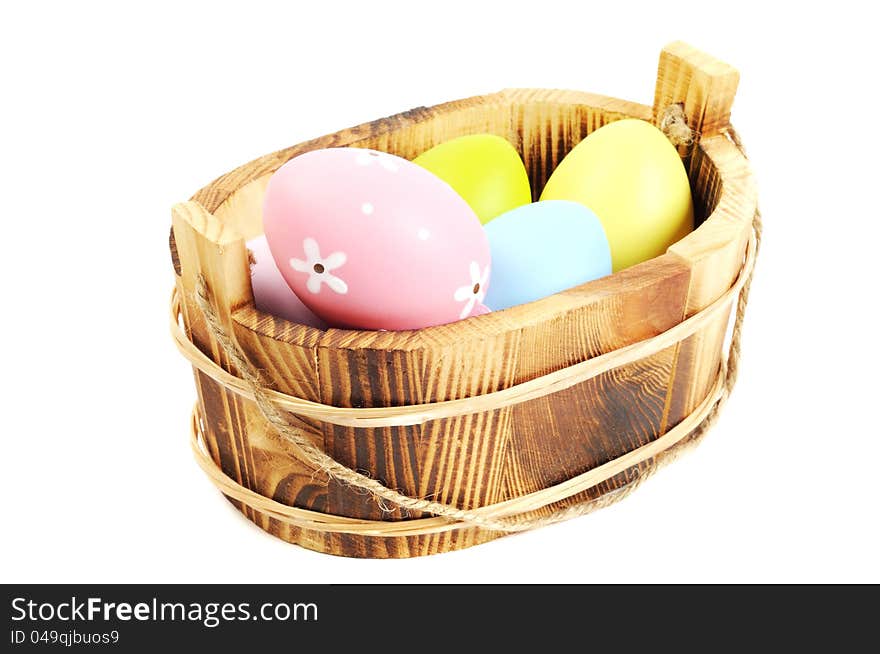 Colorful painted Easter eggs in a wooden plate, white background