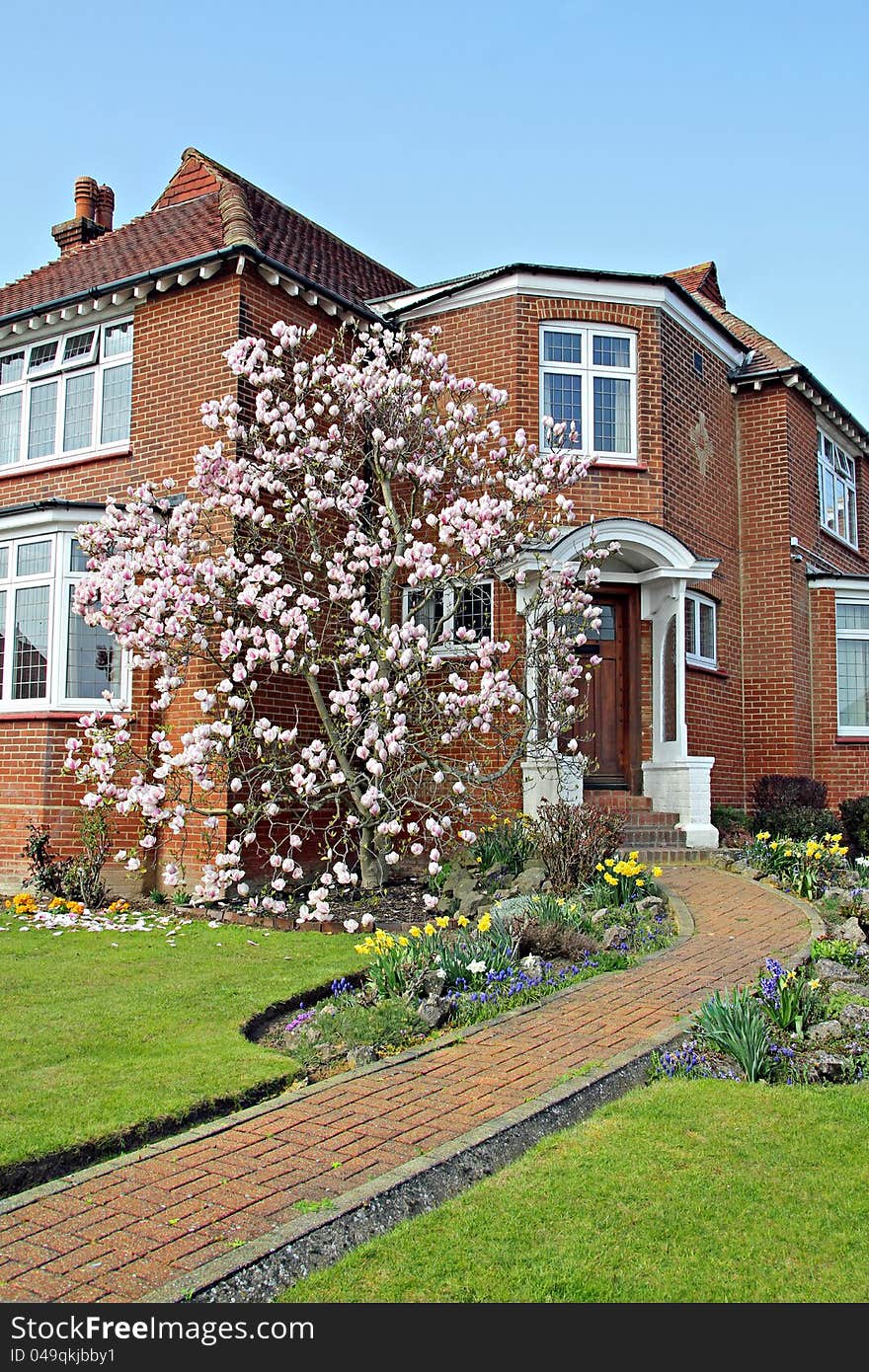 Photo of a beautiful kent country cottage house with immaculate landscaped garden with a lovely magnolia tree in full bloom. Photo of a beautiful kent country cottage house with immaculate landscaped garden with a lovely magnolia tree in full bloom.