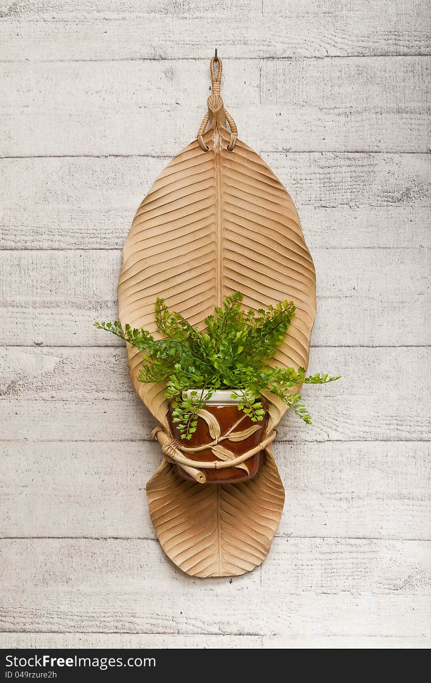 Pottery banana leaf with flowerpot isolated on wooden floor