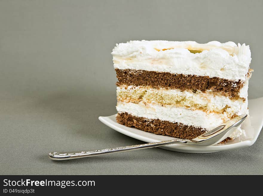 Cake lies on a saucer and tea spoon