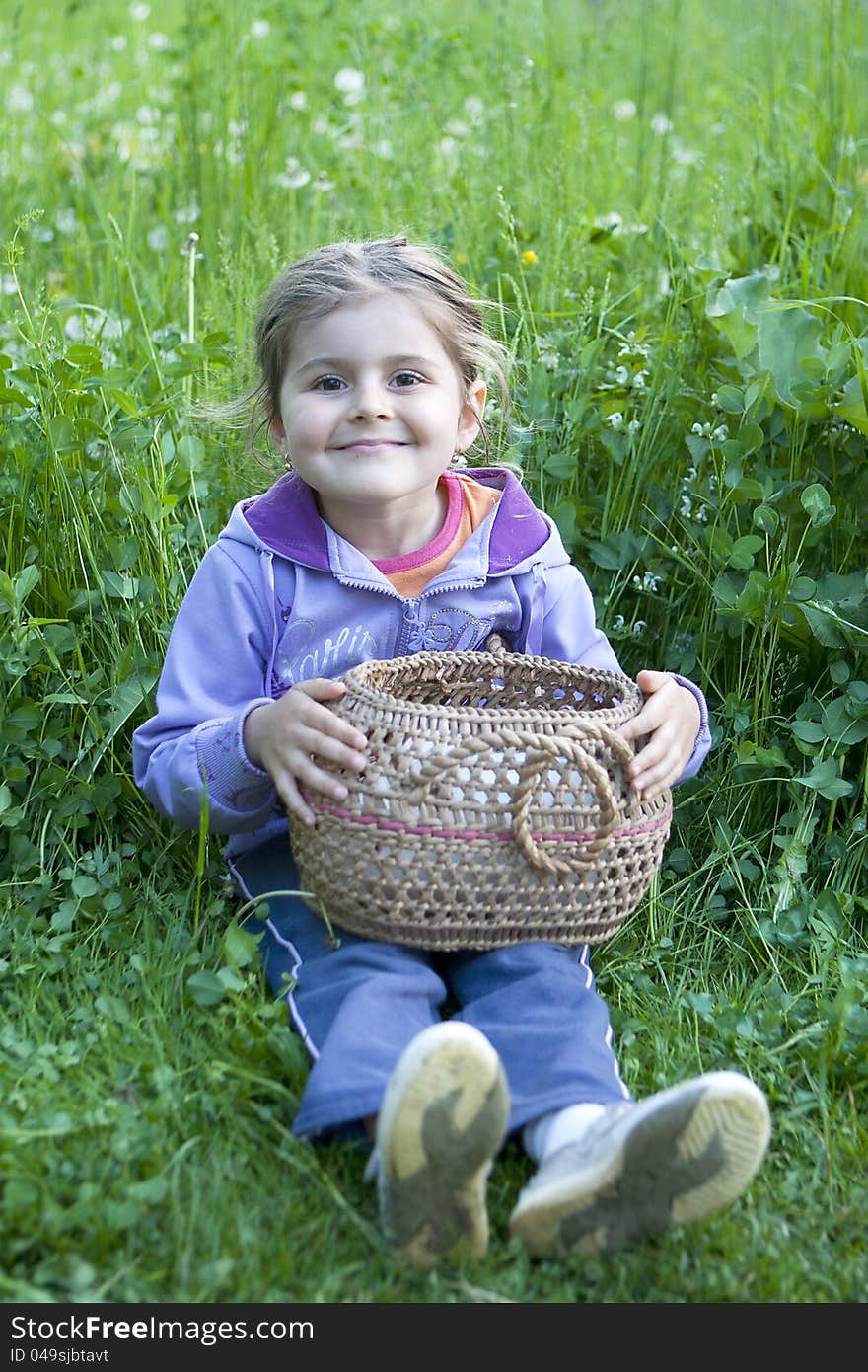 Little girl with basket on the grass