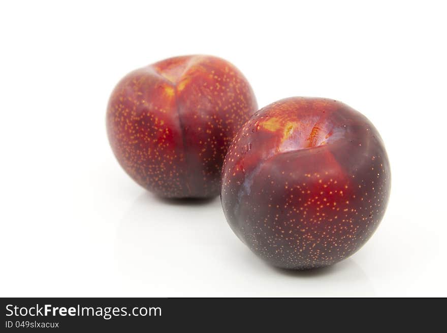 Delicious ripe red plums with white background