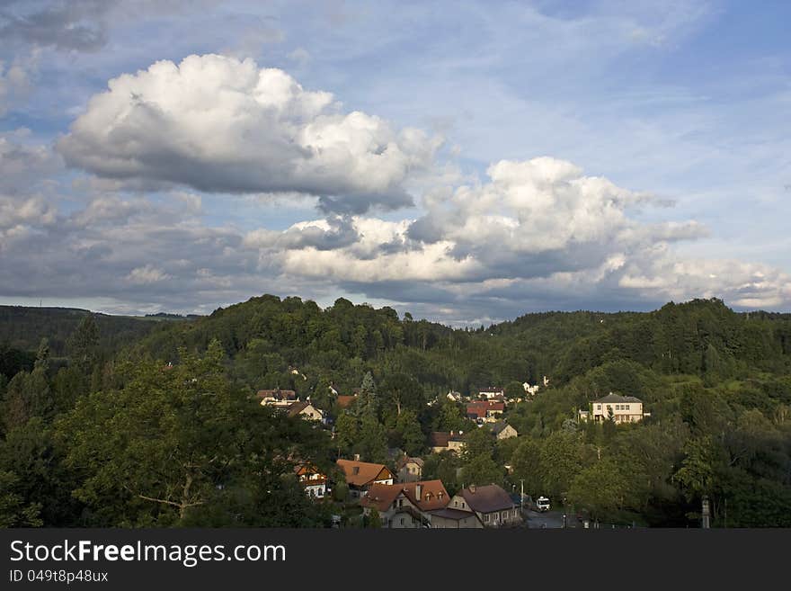 View of few houses in hilly area with cloudy summer sky. View of few houses in hilly area with cloudy summer sky