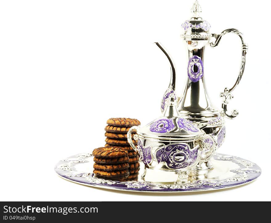 Chocolate cookies serve with metal tea set  on a white background. Chocolate cookies serve with metal tea set  on a white background