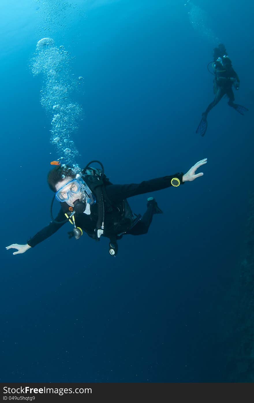 Scuba diver swimming in clear blue water