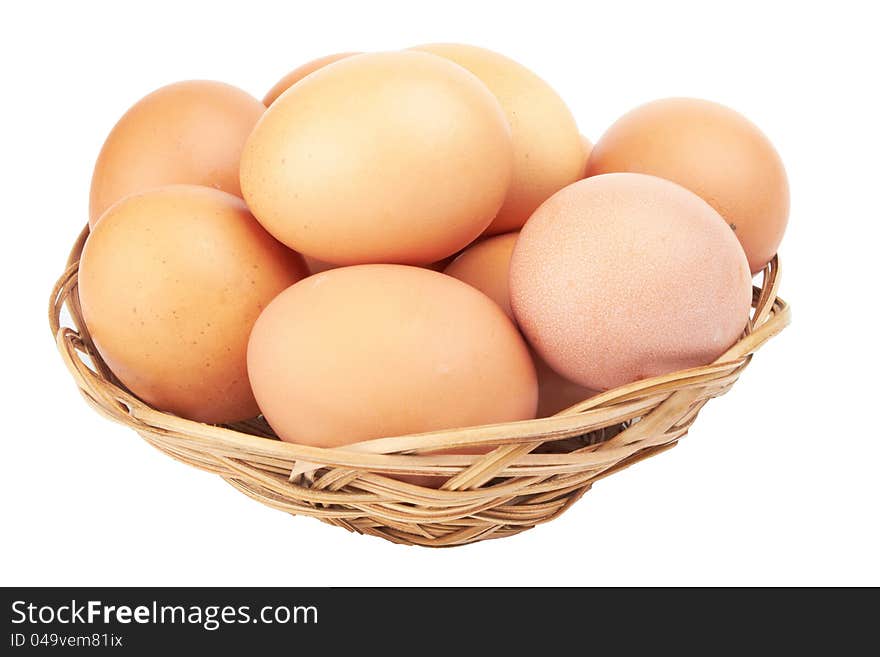 Brown eggs in the basket on white